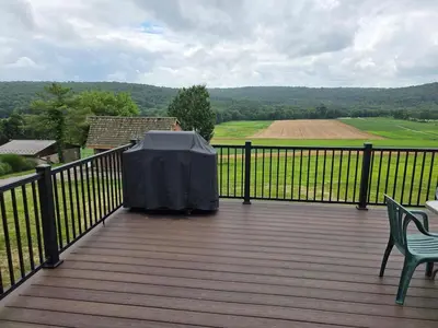 a deck with a table and two chairs on it at Just Like Home, Overlooks Maple Grove Raceway in Mohnton