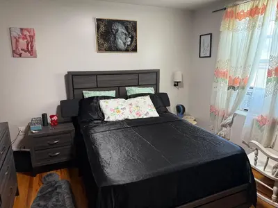 a bedroom with a large black bed and a dresser at Private Room 15 Mins to Times Square NYC in West New York