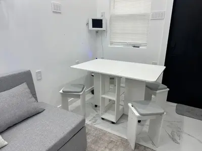 a living room with a white table and a couch at Modern Tiny Home Fast NYC Access Private in Jersey City