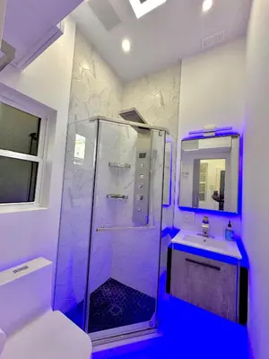 a bathroom with a glass shower and a sink at Modern Tiny Home Fast NYC Access Private in Jersey City