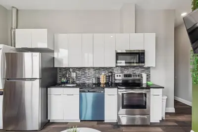 a kitchen with white cabinets and stainless steel appliances at Stay at Luna on 16th & Ridge Ave in Philadelphia