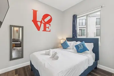 a bedroom with a blue and white bed with a sign on the wall at Stay at Luna on 16th & Ridge Ave in Philadelphia