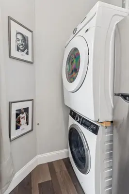 a washer and dryer in a room with two pictures at Stay at Luna on 16th & Ridge Ave in Philadelphia