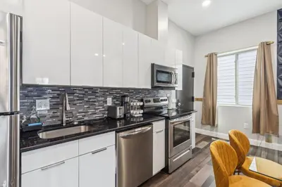 a kitchen with white cabinets and stainless steel appliances at Stay at Luna on 16th & Ridge Ave in Philadelphia