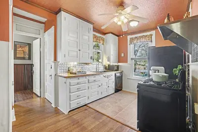 a kitchen with white cabinets and a black stove at The Manheim Manor in Manheim