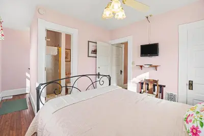 a bedroom with a large bed in a room with pink walls at The Manheim Manor in Manheim