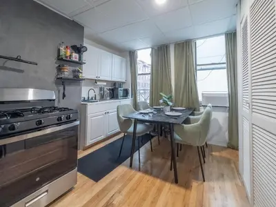 a kitchen with a table with chairs and a stove at New Calm Cocoon by Train We Pay Half Parking, Sleeps 6 in Hoboken