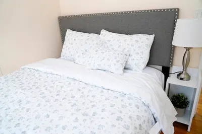 a white bed with a gray headboard and pillows at Family River Valley Retreat with Fireplace in Sparrow Bush