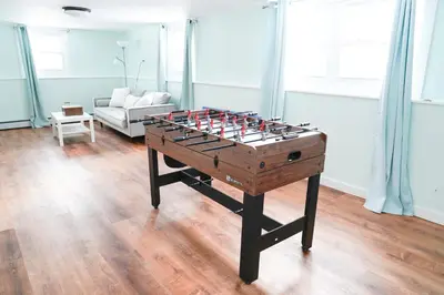a foosball table in the middle of a living room at Family River Valley Retreat with Fireplace in Sparrow Bush