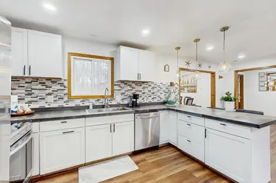 a kitchen with white cabinets and a sink at Lakeside Escape in Blakeslee