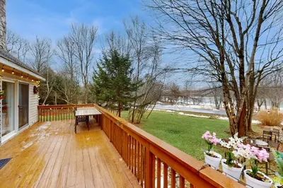 a wooden deck with a piano and flowers on it at Lakeside Escape in Blakeslee