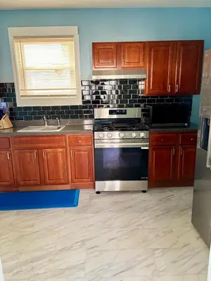 a kitchen with wooden cabinets and a stove top oven at Heavenly Retreat Luxury 3 Bedrooms 1 Bathroom in East Orange