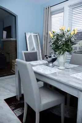 a dining room table with a vase of yellow flowers at Heavenly Retreat Luxury 3 Bedrooms 1 Bathroom in East Orange