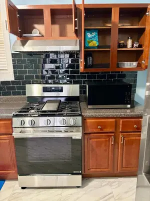 a kitchen with a stove and a microwave at Heavenly Retreat Luxury 3 Bedrooms 1 Bathroom in East Orange