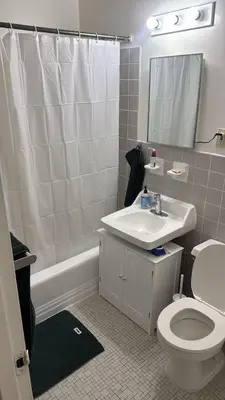 a bathroom with a sink and a toilet and a mirror at Elegant NYC Apartment with Designer Touches in New York