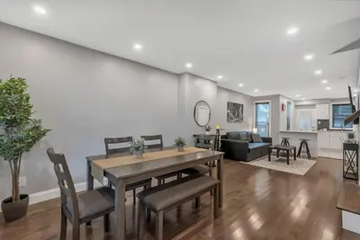 a kitchen and living room with a table and chairs at University City Executive Modern 3BR 2BA Within 5 min to Drexel, University of Pennsylvania, & Children's Hospital of Pennsylvania in Philadelphia