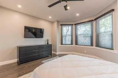 a bedroom with a large bed and a flat screen tv at University City Executive Modern 3BR 2BA Within 5 min to Drexel, University of Pennsylvania, & Children's Hospital of Pennsylvania in Philadelphia