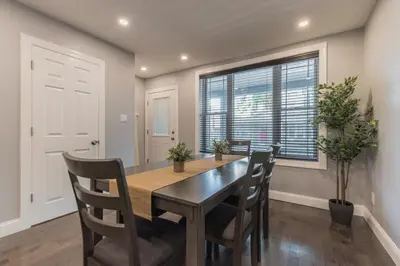 a dining room with a table and chairs and a window at University City Executive Modern 3BR 2BA Within 5 min to Drexel, University of Pennsylvania, & Children's Hospital of Pennsylvania in Philadelphia