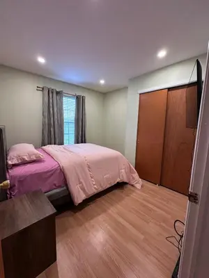 a bedroom with a bed and a wooden floor at Home Away From Home in Ridley Park