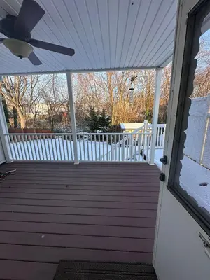 a porch with a white fence and a ceiling fan at Home Away From Home in Ridley Park