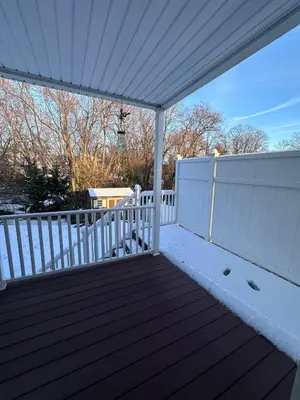 a porch with a white fence and snow on it at Home Away From Home in Ridley Park