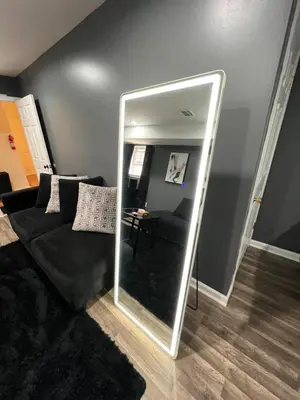 a mirror in a living room with a black couch at Comfortstayrus in Orange