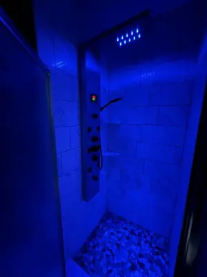 a blue room with a shower with a blue ceiling at Comfortstayrus in Orange