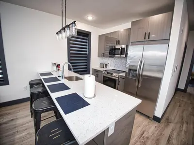 a kitchen with a white counter and a refrigerator at Luxurious and Spacious Apt with Parking 20 min to NYC in West New York