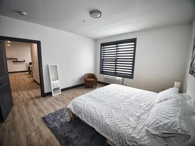 a bedroom with a bed and a window and a chair at Luxurious and Spacious Apt with Parking 20 min to NYC in West New York