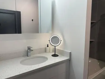 a bathroom with a sink and a mirror at Luxurious and Spacious Apt with Parking 20 min to NYC in West New York