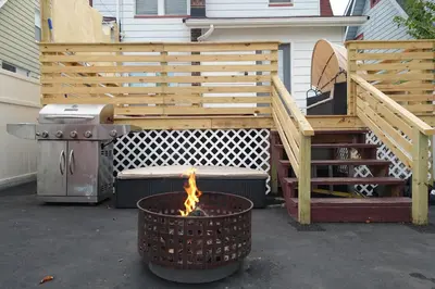 a patio with a grill and a fire pit at Best RV-Camper To Visit NYC-Hot Tub-Free Parking in Hillside