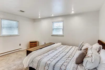 a bedroom with a large bed and two windows at Family Home on Greenbelt, 4 Mi to Dtwn Harrisburg! in Harrisburg
