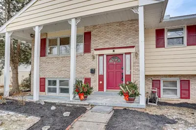 a red door on a brick house with red shutters at Family Home on Greenbelt, 4 Mi to Dtwn Harrisburg! in Harrisburg