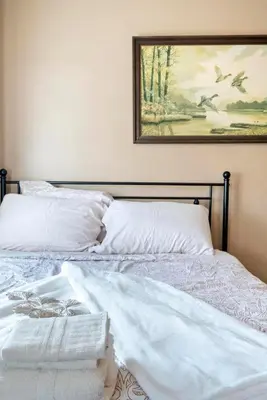 a bed with white sheets and a painting on the wall at The Serenity Manor in Chester