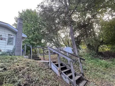 a wooden staircase in front of a house at Cheerful two bedroom bungalow near Mountain Creek in West Milford