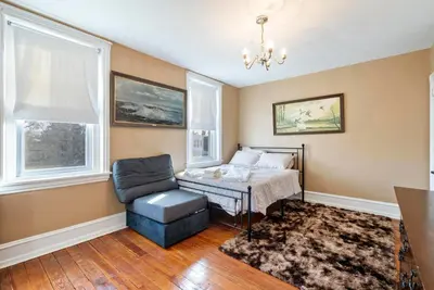 a bedroom with a bed and a chair and windows at Candlelight Chamber - Private Room with Shared Space in Chester