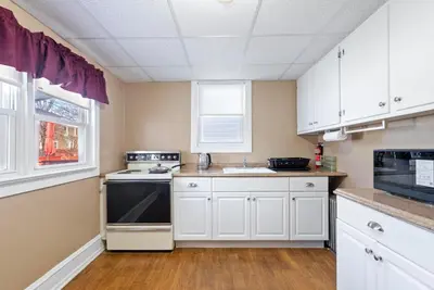 a kitchen with white cabinets and a black oven at Candlelight Chamber - Private Room with Shared Space in Chester