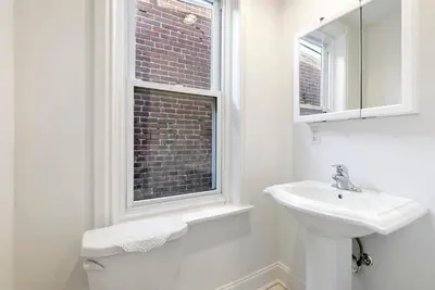 a white bathroom with a sink and a window at Candlelight Chamber - Private Room with Shared Space in Chester