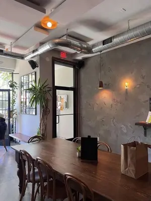 a large wooden table in a room with chairs at 20 Minutes to Times Square, Stylish 2 Bedroom Apartment in West New York