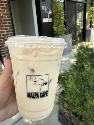 a hand holding a cup of iced coffee at 20 Minutes to Times Square, Stylish 2 Bedroom Apartment in West New York