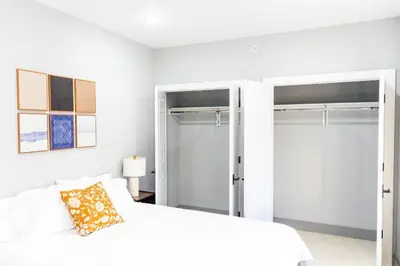 a bedroom with a white bed and sliding glass doors at Stylish Two Bedroom Apartment with Free Indoor Parking in West New York