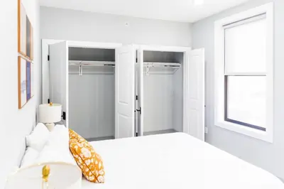 a white bedroom with a bed and a window at Stylish Two Bedroom Apartment with Free Indoor Parking in West New York
