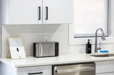 a kitchen counter with a microwave and a cutting board at Stylish Two Bedroom Apartment with Free Indoor Parking in West New York