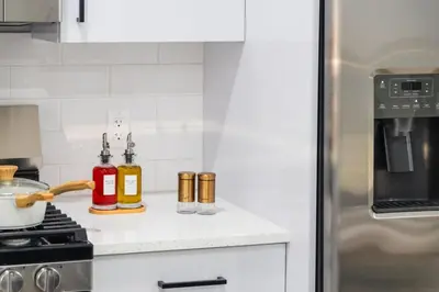 a kitchen with two bottles of oils on a counter at 20 Minutes to Times Square with Free Indoor Parking in West New York