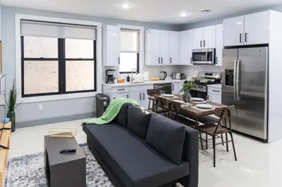 a kitchen and living room with a couch and a table at 20 Minutes to Times Square with Free Indoor Parking in West New York