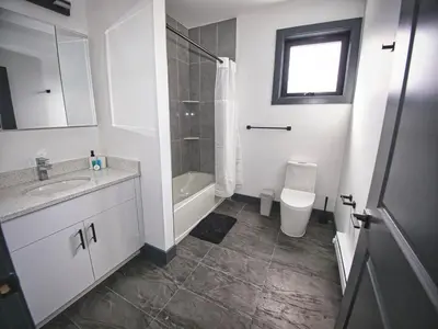 a bathroom with a sink and a shower and a toilet at Spacious Apt 15 mins to NYC with Free Indoor Parking in West New York