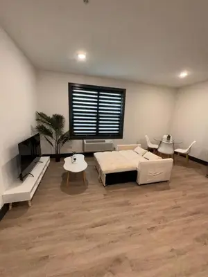 a large living room with a bed and a table at Spacious Apt 15 mins to NYC with Free Indoor Parking in West New York
