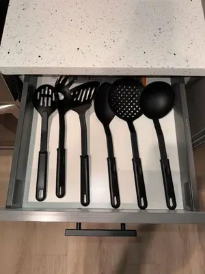 a rack of utensils on a shelf under a counter at Spacious Apt 15 mins to NYC with Free Indoor Parking in West New York