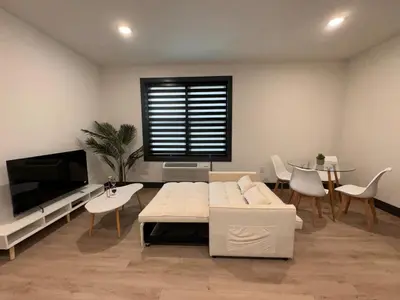 a living room with a white couch and a tv at Spacious Apt 15 mins to NYC with Free Indoor Parking in West New York