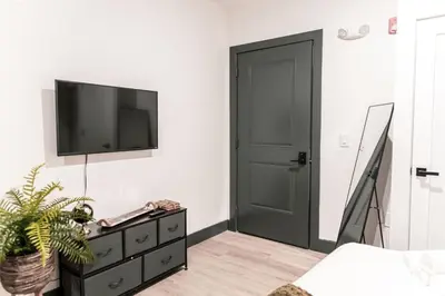 a bedroom with a black door and a tv on a wall at Discover NYC in stylish Studio-25 mins to NYC in West New York